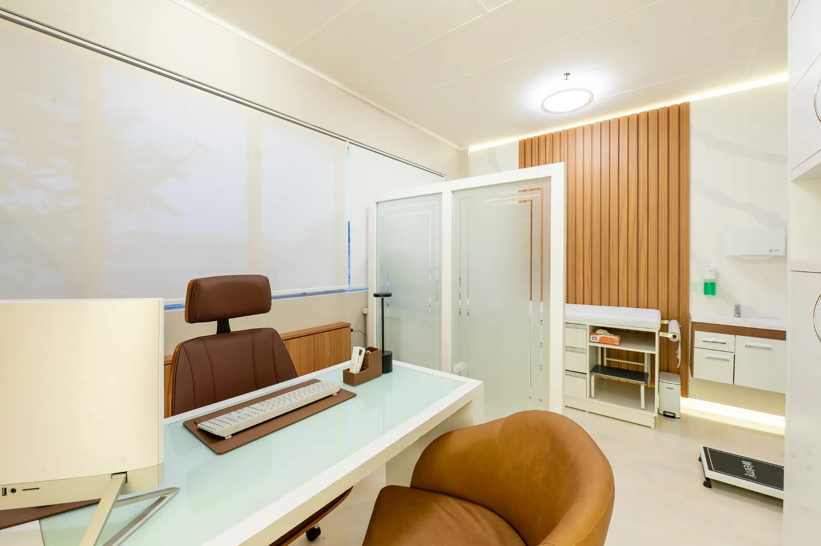 Consultório com mesa de atendimento e maca de exames